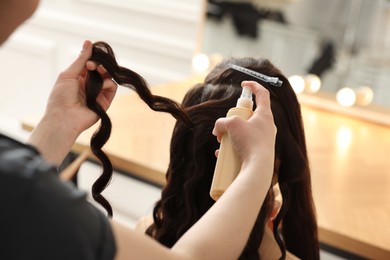 Hair styling. Professional hairdresser working with client in salon, closeup