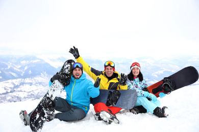 Friends with snowboards at mountain resort. Winter vacation