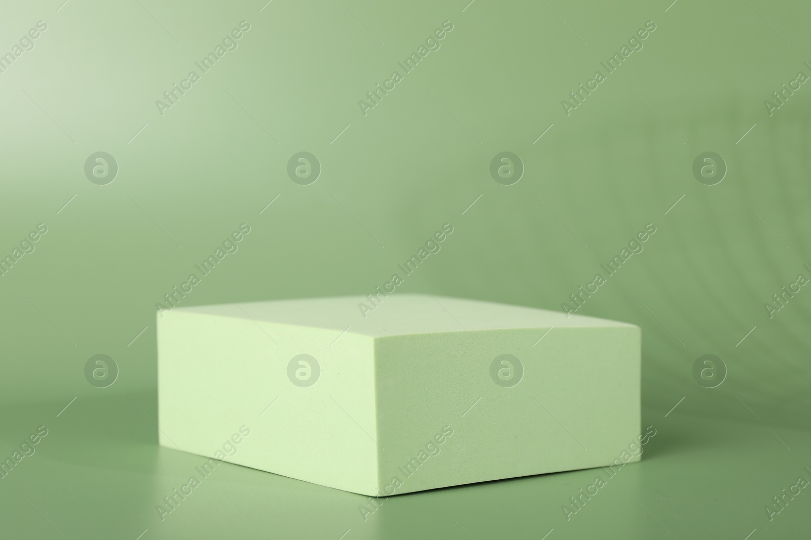 Photo of Presentation of product. Podium and shadows on green background. Space for text