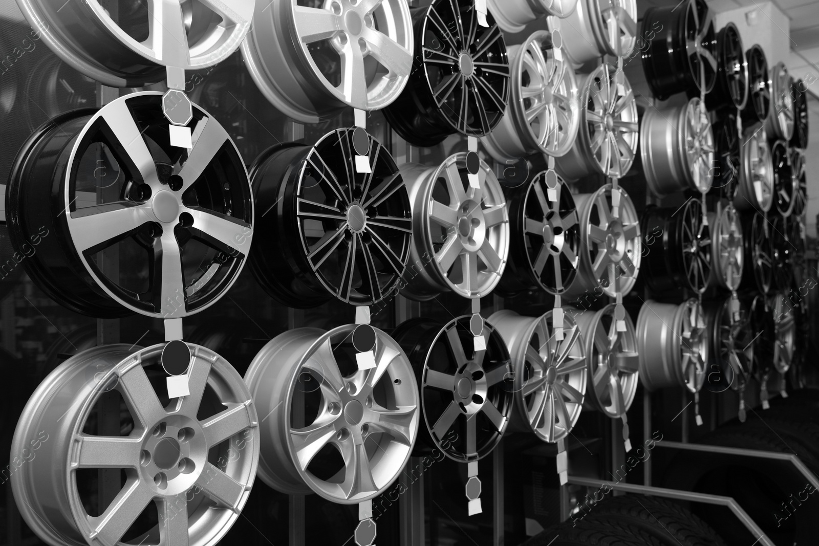 Image of Alloy wheels on rack in auto store. Black and white effect