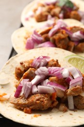 Photo of Delicious tacos with vegetables and meat on table, closeup