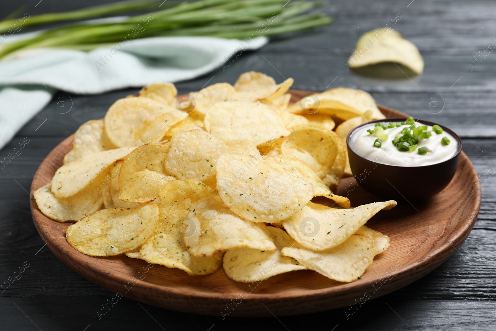 Photo of Chips with sour cream dressing on grey wooden table