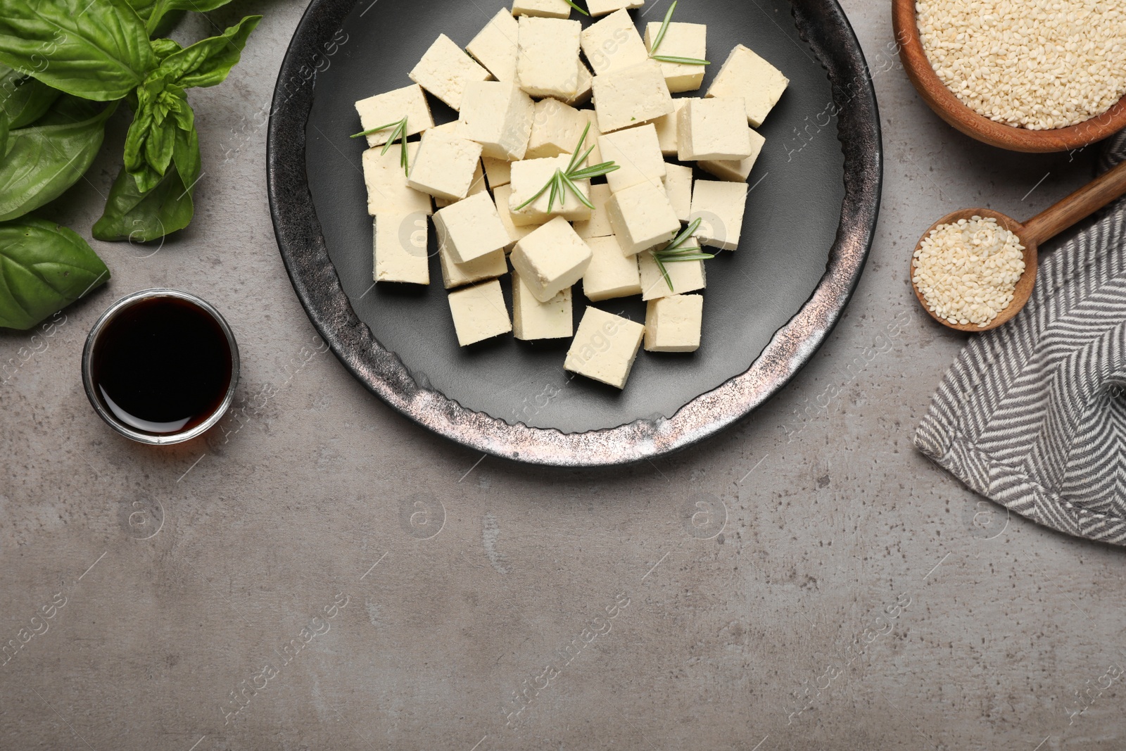 Photo of Delicious tofu with rosemary served on grey table, flat lay