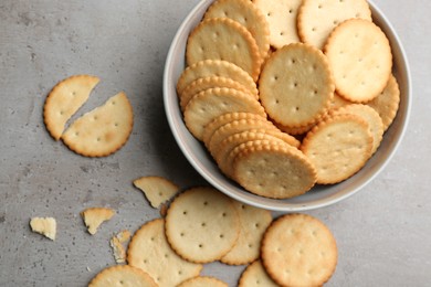 Delicious crispy crackers on grey table, flat lay