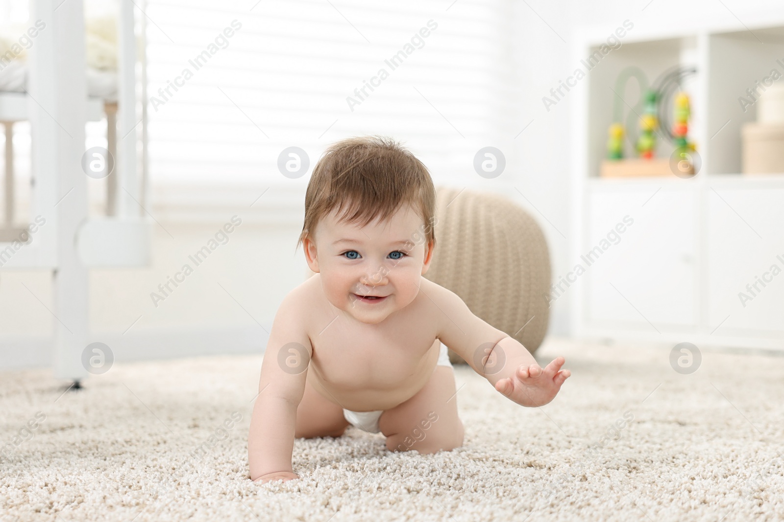 Photo of Cute baby boy crawling on carpet at home