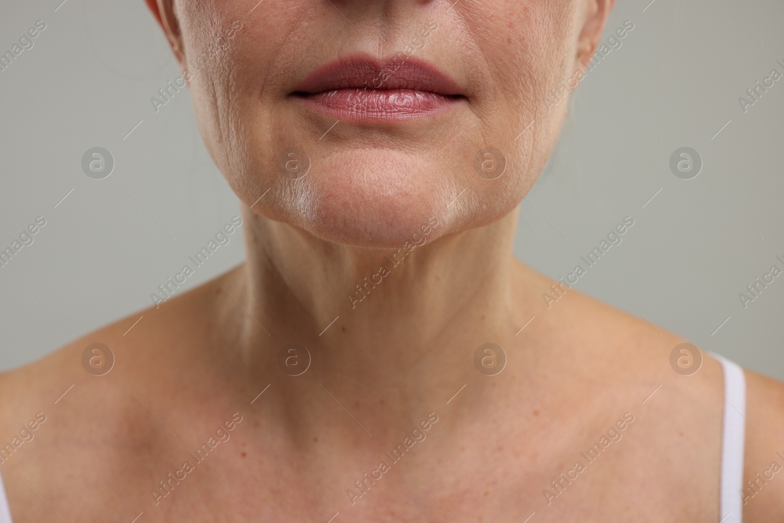 Photo of Mature woman with healthy skin on grey background, closeup