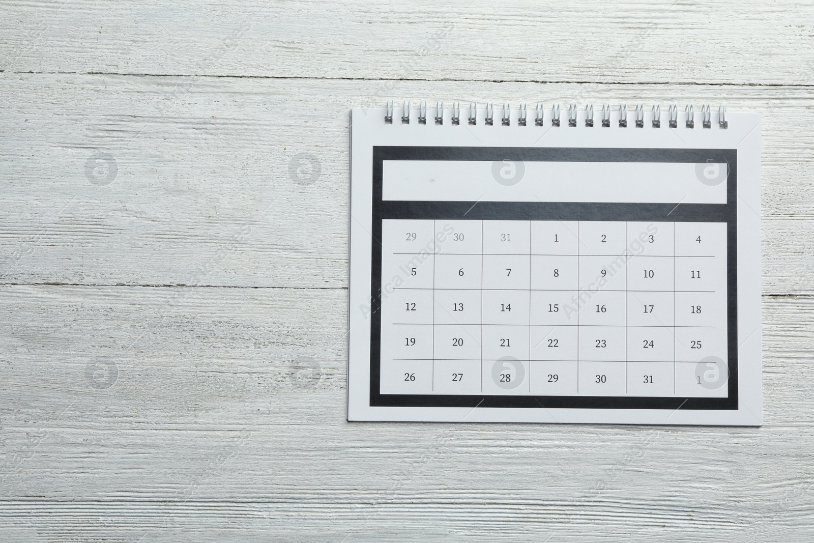 Photo of Paper calendar on white wooden background, top view. Space for text