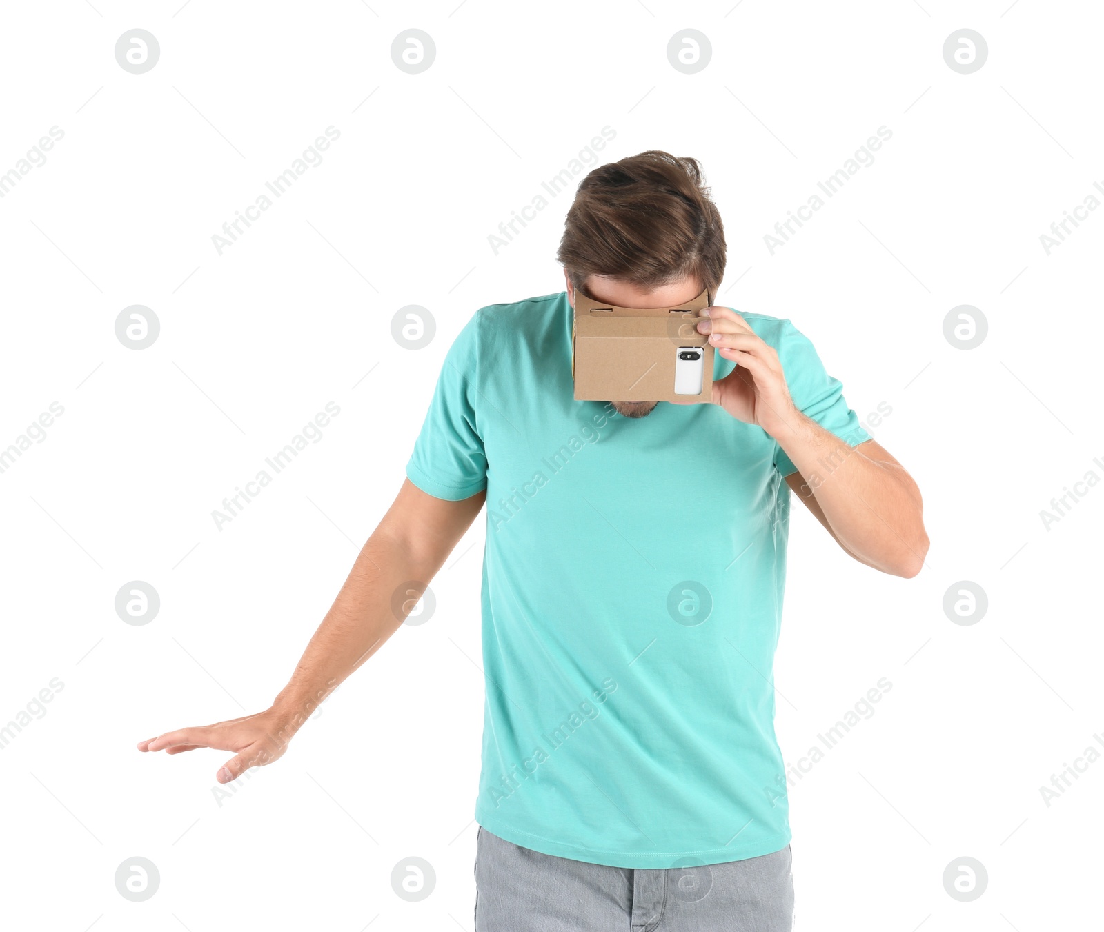 Photo of Young man using cardboard virtual reality headset, isolated on white