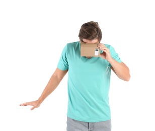 Photo of Young man using cardboard virtual reality headset, isolated on white