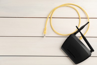 Modern Wi-Fi router on white wooden background, top view. Space for text