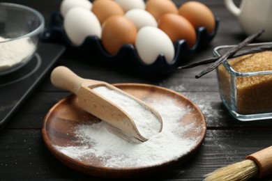 Baking powder and other products on black wooden table, closeup