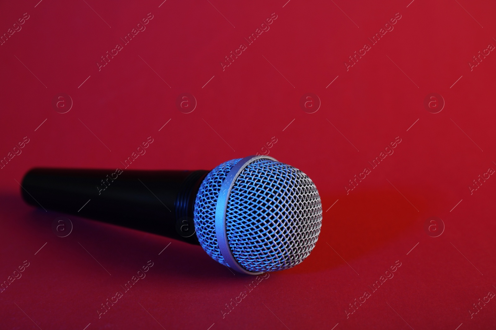 Photo of Modern microphone on color background. Space for text