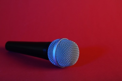 Photo of Modern microphone on color background. Space for text