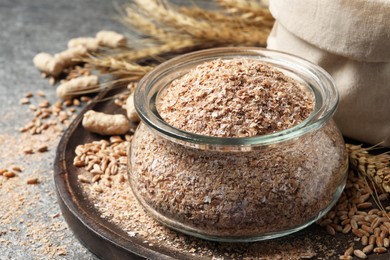 Photo of Jar of wheat bran on grey table