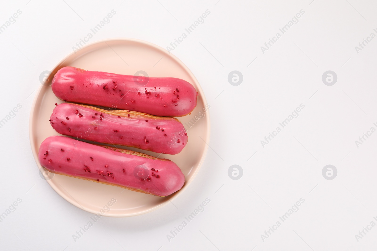 Photo of Delicious eclairs covered with glaze on white background, top view