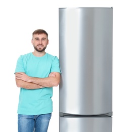 Photo of Young man near closed refrigerator on white background