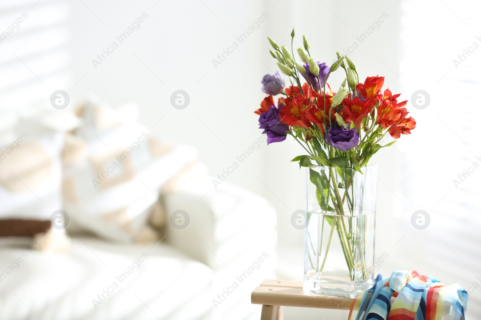Photo of Vase with beautiful flowers on wooden table in room, space for text
