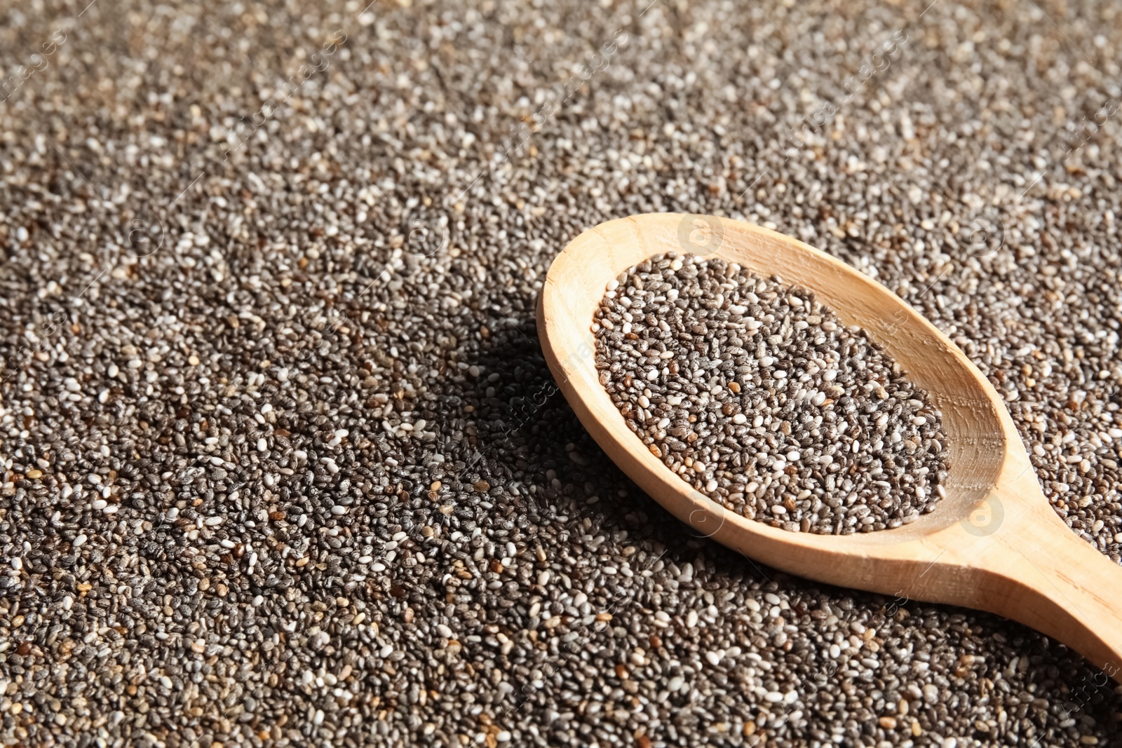 Photo of Spoon of chia seeds on grains, closeup. Space for text