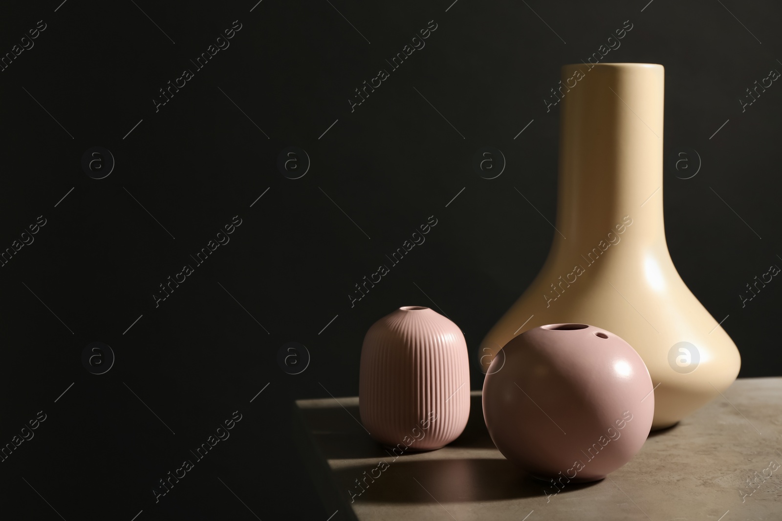 Photo of Stylish empty ceramic vase on table against black background, space for text