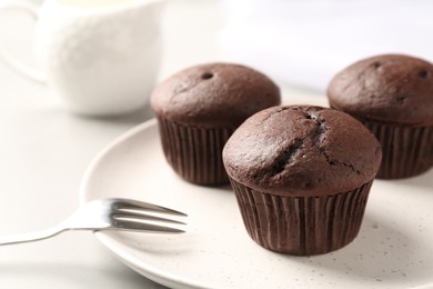 Photo of Delicious chocolate cupcakes on white table, closeup