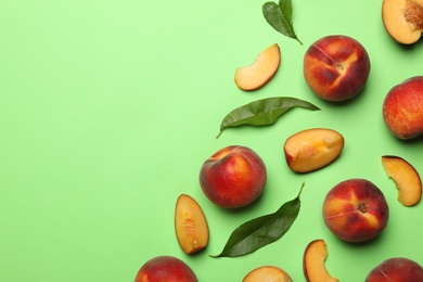 Photo of Flat lay composition with sweet juicy peaches on green background, space for text