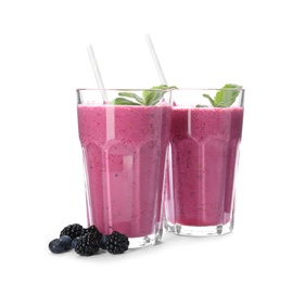 Photo of Tasty fresh milk shakes with berries on white background