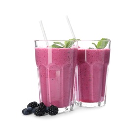 Tasty fresh milk shakes with berries on white background