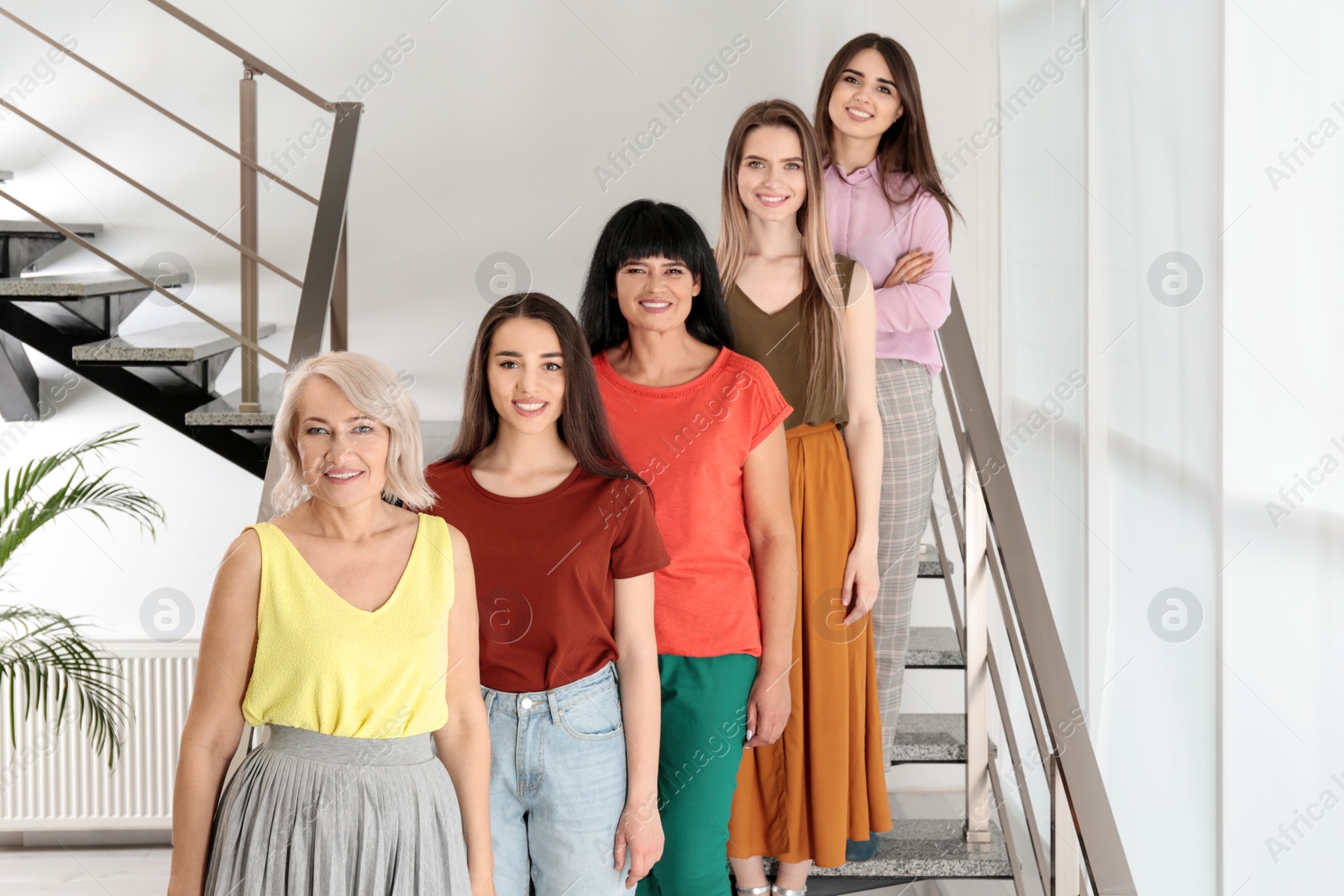 Photo of Group of ladies on stairs indoors. Women power