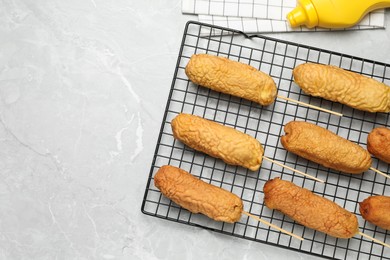 Photo of Delicious corn dogs on grey table, flat lay. Space for text