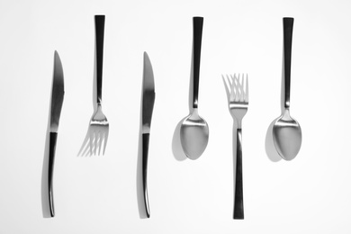 Photo of Composition with steel cutlery on white background, top view