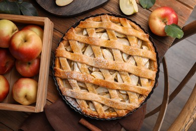 Photo of Delicious traditional apple pie on wooden table, flat lay