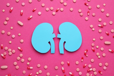 Photo of Paper cutout of kidneys and pills on magenta background, flat lay