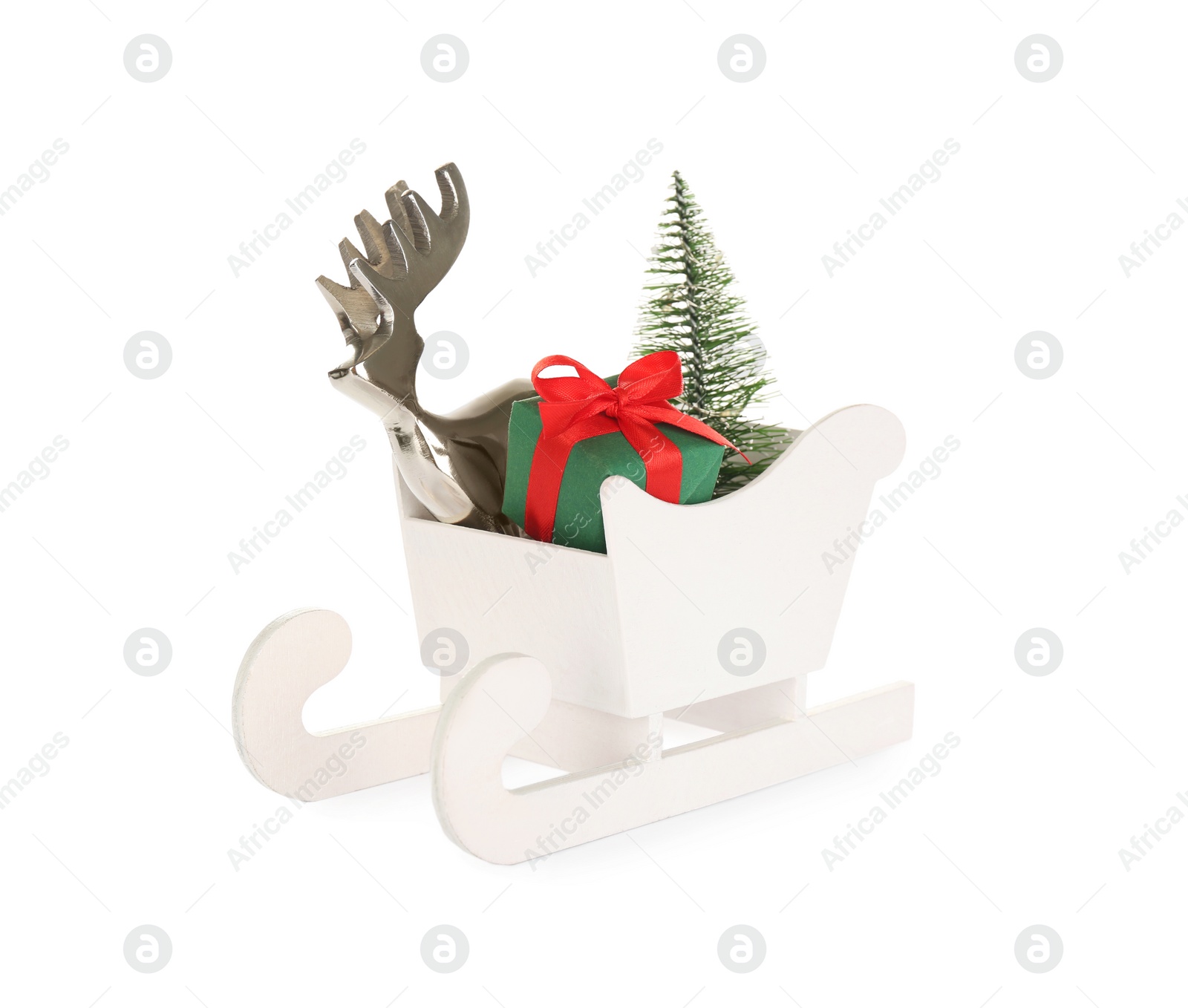 Photo of Wooden sleigh with present, decorative reindeer and fir tree on white background. Christmas holidays