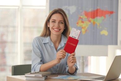 Travel agent with ticket and passport in office