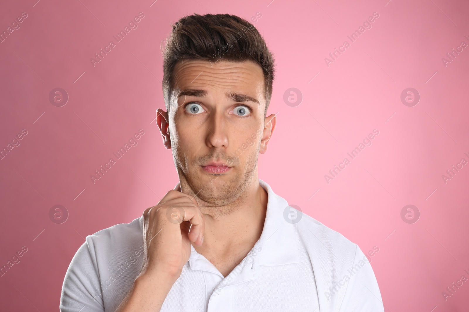 Photo of Emotional young man with double chin on pink background