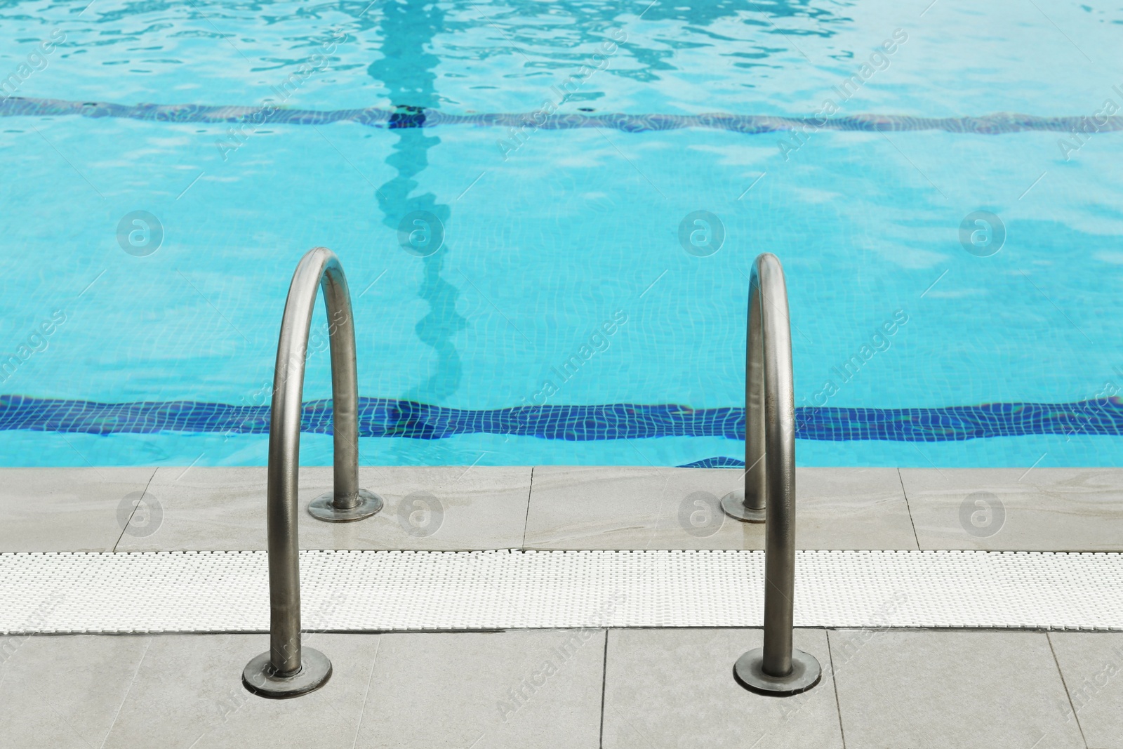 Photo of Ladder with handrails in outdoor swimming pool