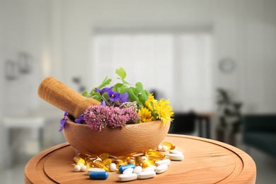 Image of Mortar, fresh herbs and pills on wooden board in medical office