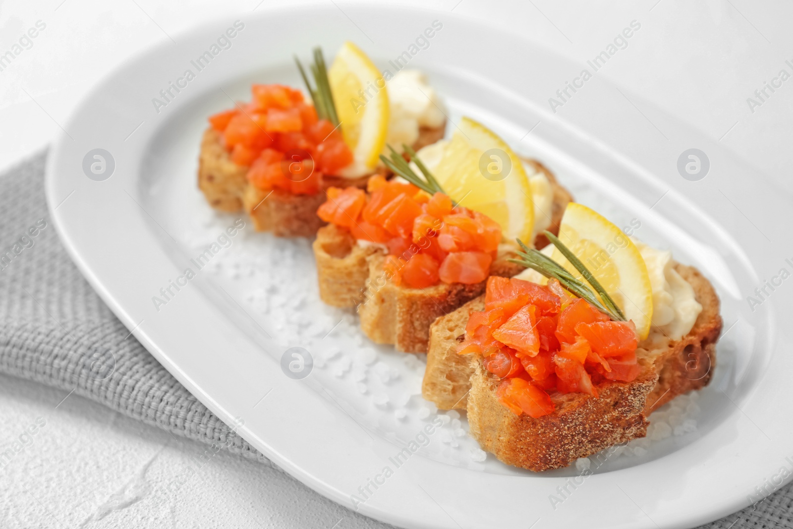 Photo of Tasty sandwiches with fresh sliced salmon fillet on plate, closeup