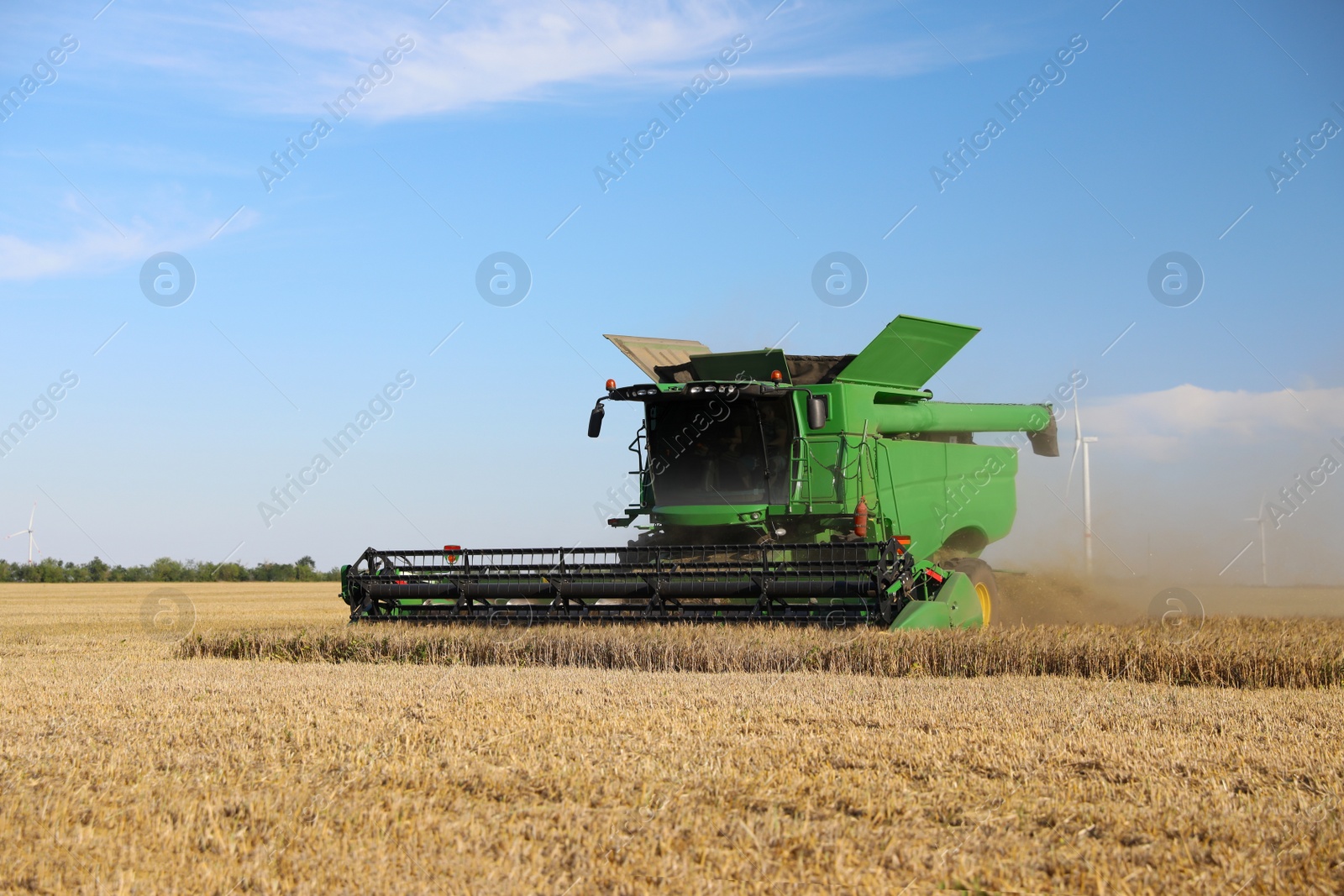 Photo of Modern combine harvester working in agricultural field