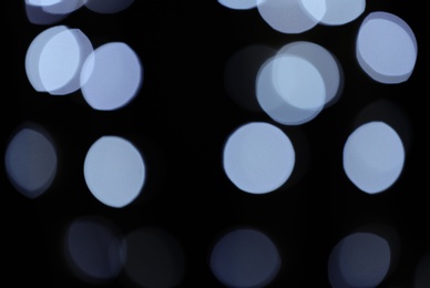 Blurred view of festive lights on dark background. Bokeh effect