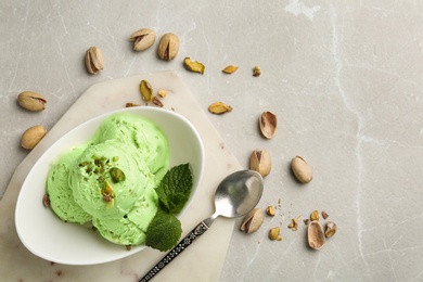Photo of Tasty pistachio ice cream served on grey table, flat lay