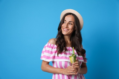 Photo of Young woman with refreshing drink on blue background