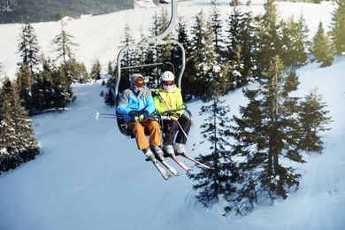 People using chairlift at mountain ski resort. Winter vacation