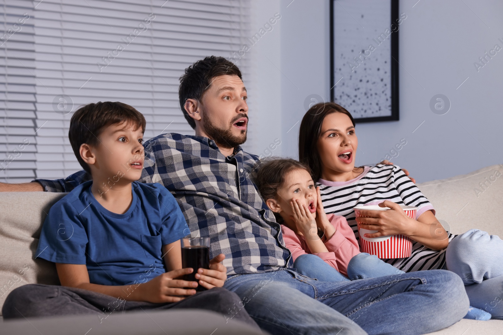 Photo of Shocked family watching TV at home in evening