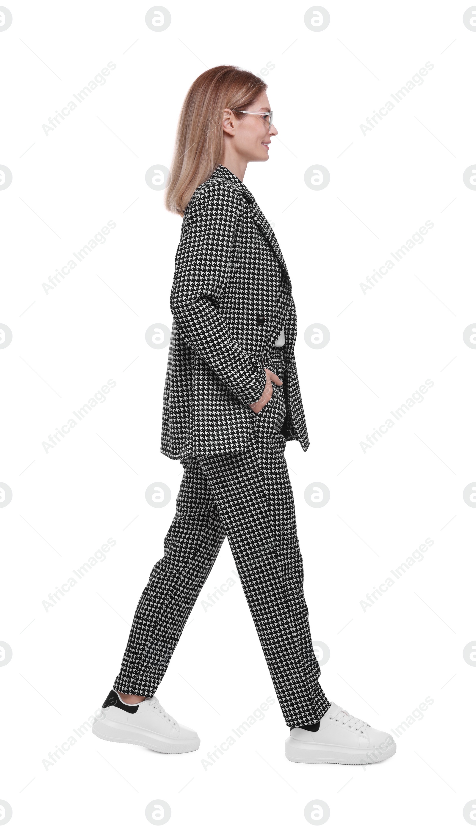 Photo of Beautiful happy businesswoman in suit walking on white background