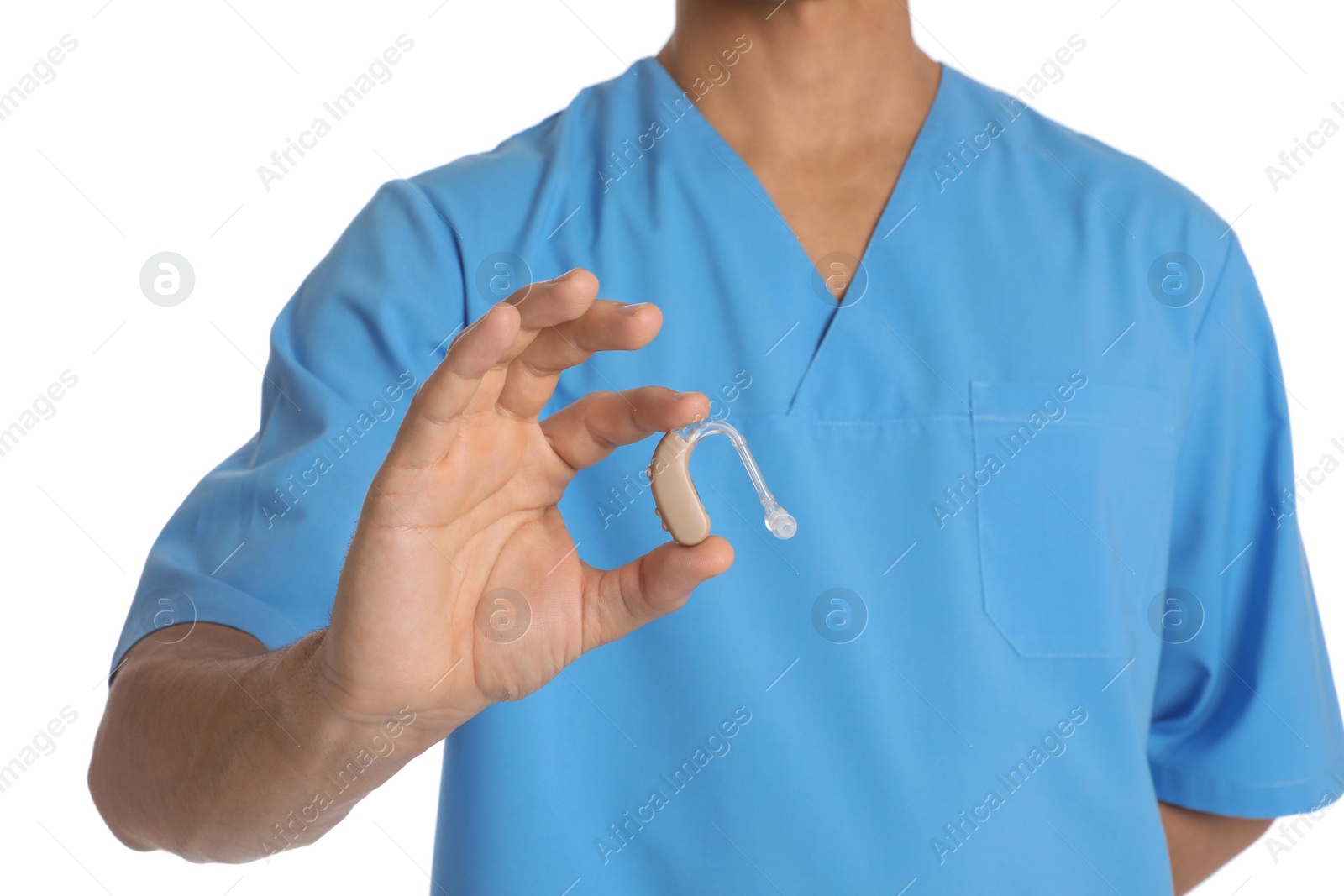 Photo of Male doctor holding hearing aid on white background, closeup. Medical object