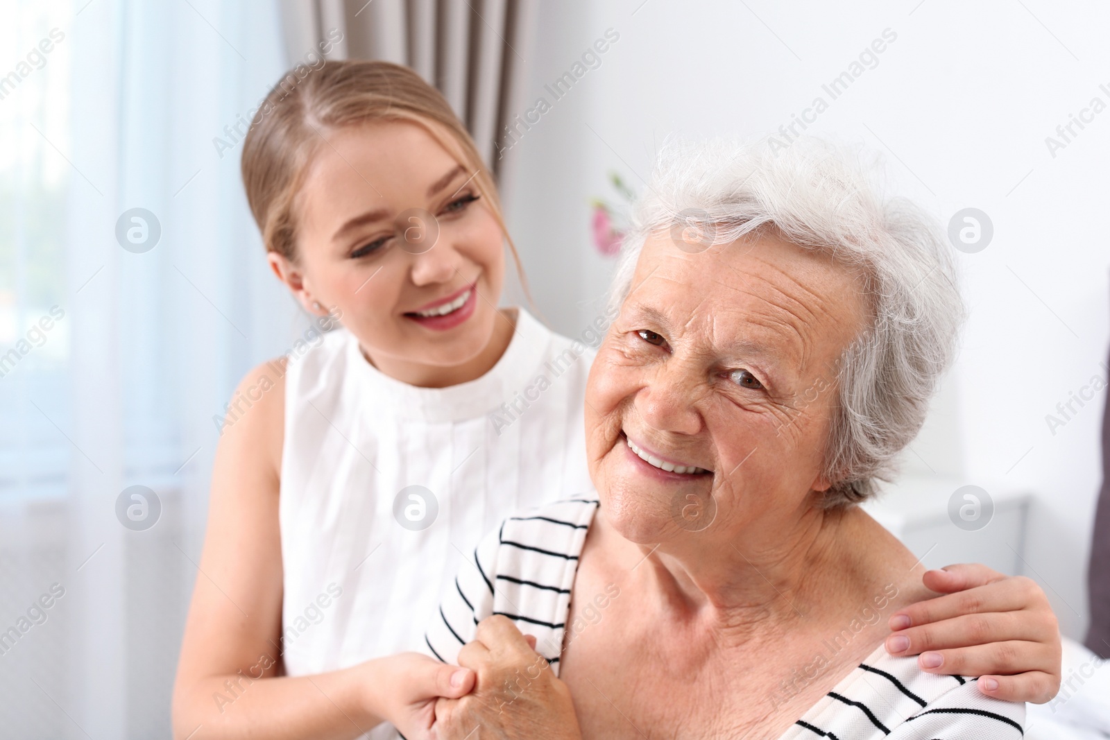 Photo of Happy young woman with her grandmother at home