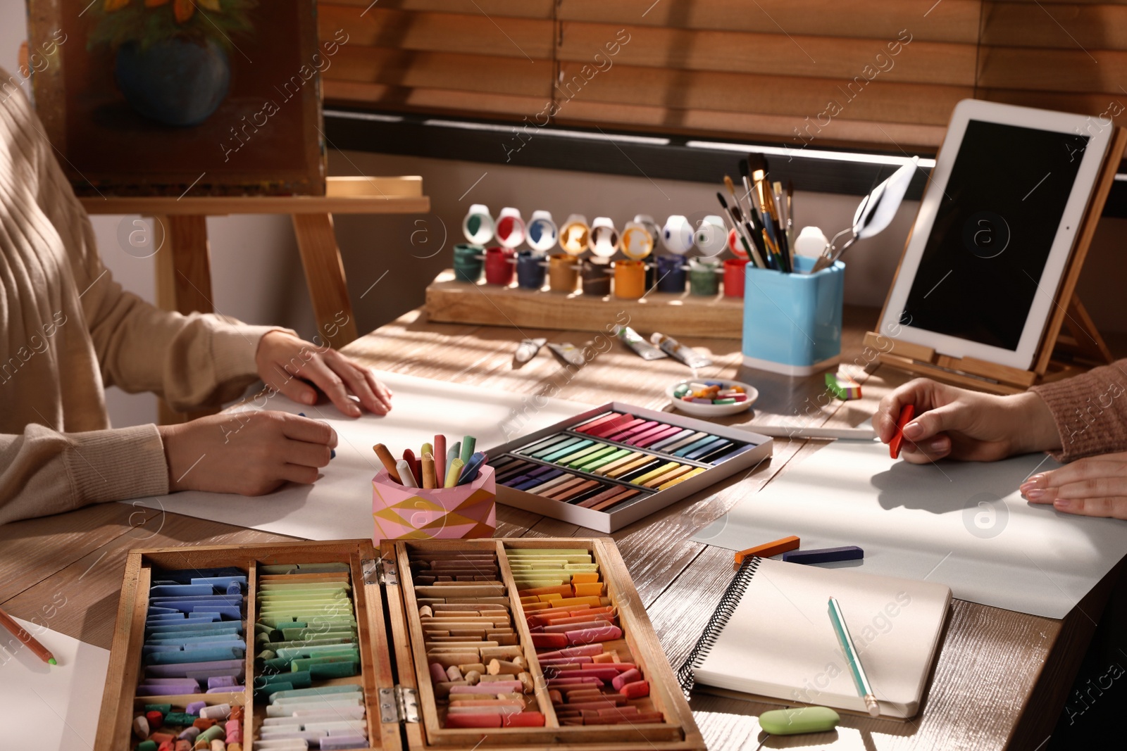 Photo of Artists drawing with soft pastels at table, closeup