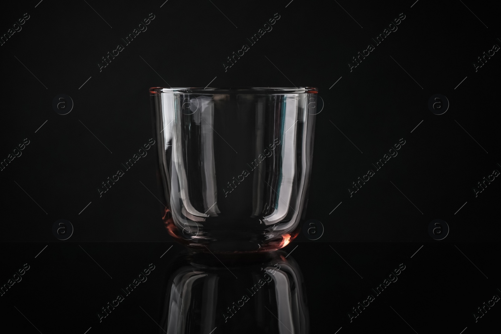 Photo of Elegant empty colorful whiskey glass on black background