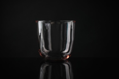 Photo of Elegant empty colorful whiskey glass on black background